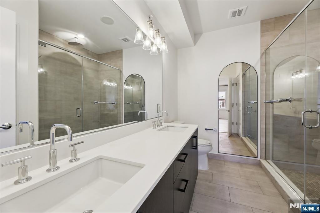 209-211 Hackensack Plank Road, Unit 5B Weehawken, NJ 07086 - Photo 8 of 30 a bathroom with a double vanity sink mirror and shower