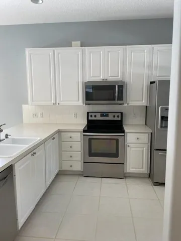 a kitchen with cabinets stainless steel appliances and a counter space