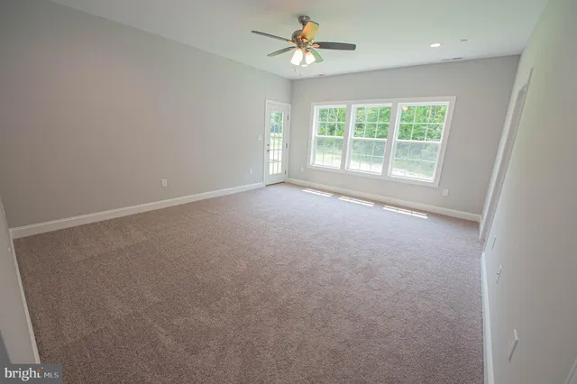 an empty room with a window and a ceiling fan