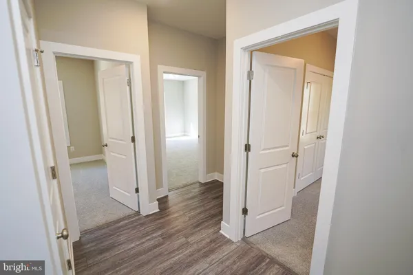 a view of an empty room with a chandelier fan