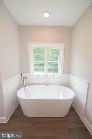 a white tub sitting in a bathroom next to a window