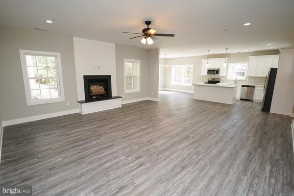 a kitchen with stainless steel appliances a sink dishwasher stove and microwave with wooden floor
