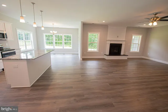 an empty room with wooden floor and fireplace
