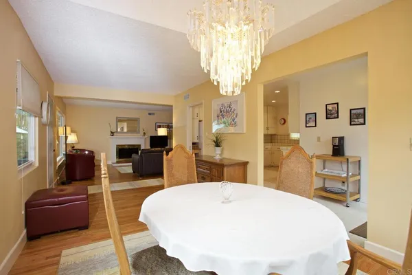 a living room with furniture a chandelier and a dining table