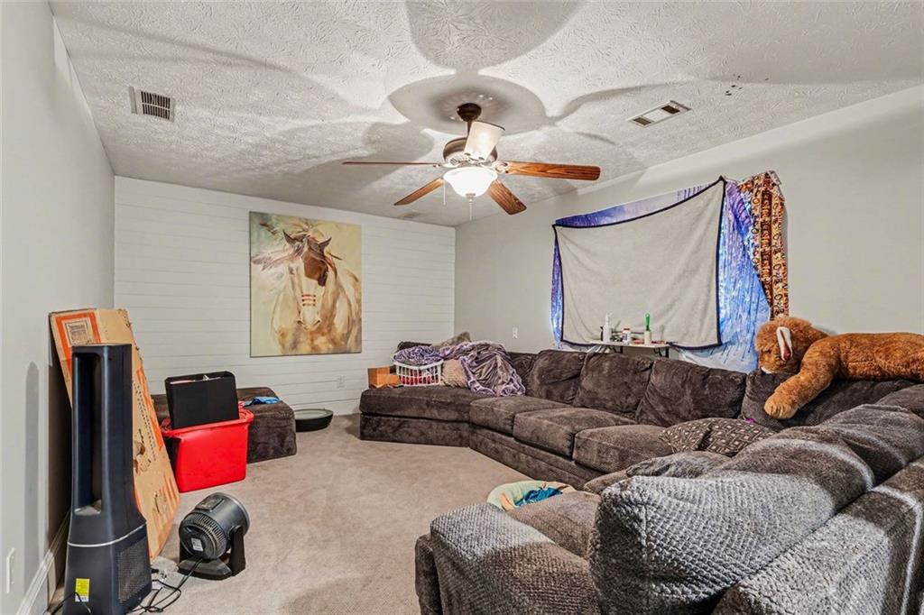 1940 Honey Creek Road Southwest Conyers, GA 30094 - Photo 17 of 31 a living room with furniture ceiling fan and a rug