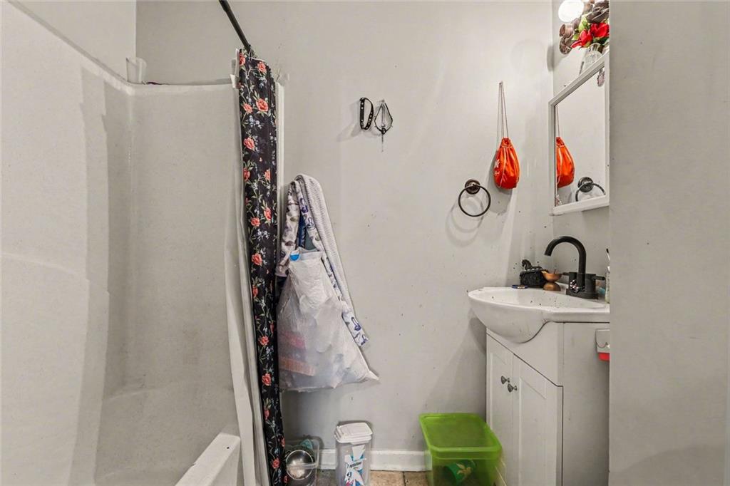 1940 Honey Creek Road Southwest Conyers, GA 30094 - Photo 19 of 31 a bathroom with a sink and a shower curtain