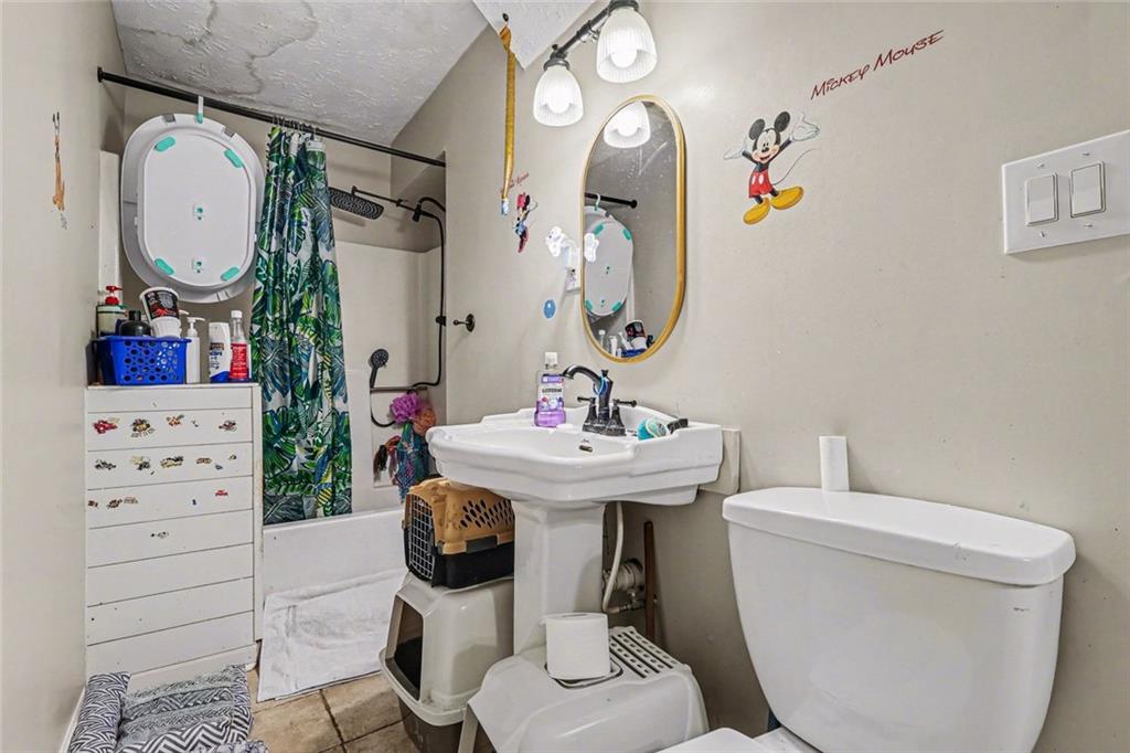 1940 Honey Creek Road Southwest Conyers, GA 30094 - Photo 21 of 31 a bathroom with a toilet a sink and a mirror