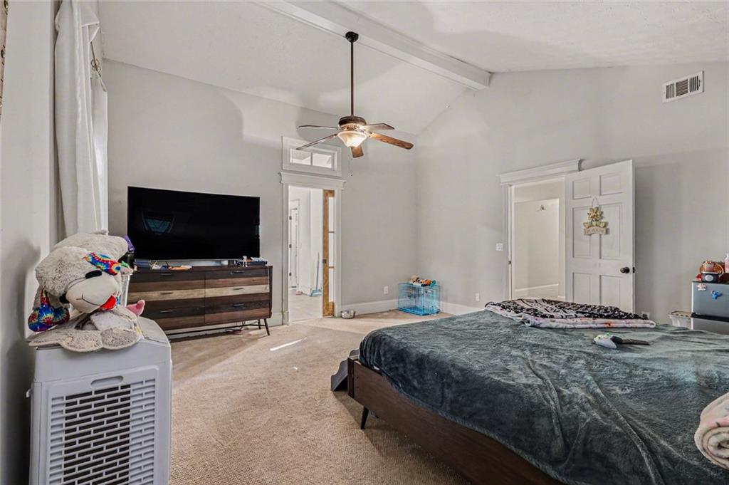 1940 Honey Creek Road Southwest Conyers, GA 30094 - Photo 8 of 31 a bedroom with a bed and a flat screen tv