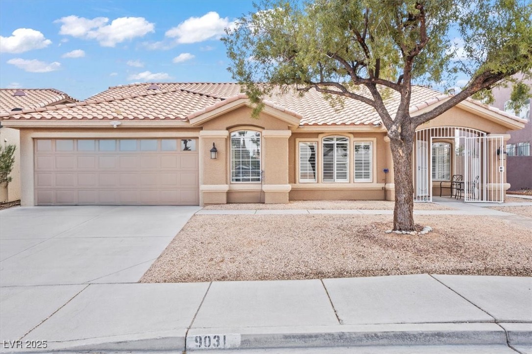 9031 West Viking Road Las Vegas, NV 89147 - Photo 1 of 33 View of front of property with stucco siding, a garage, concrete driveway, and a tiled roof