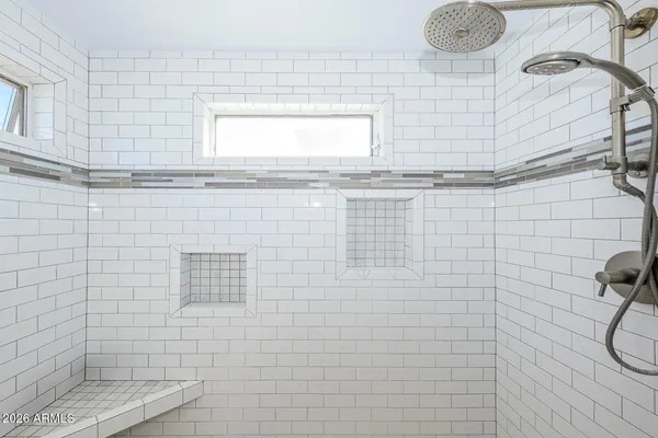 a bedroom with a bed and dresser with mirror