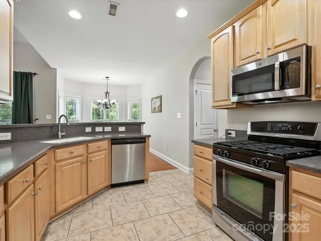 a kitchen with stainless steel appliances granite countertop a sink stove and refrigerator