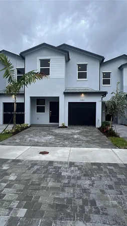 a front view of a house with a yard and a garage