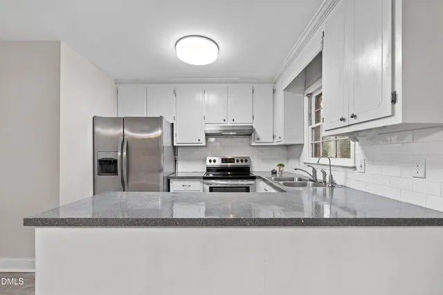 a kitchen with stainless steel appliances granite countertop a sink a stove and a granite counter tops