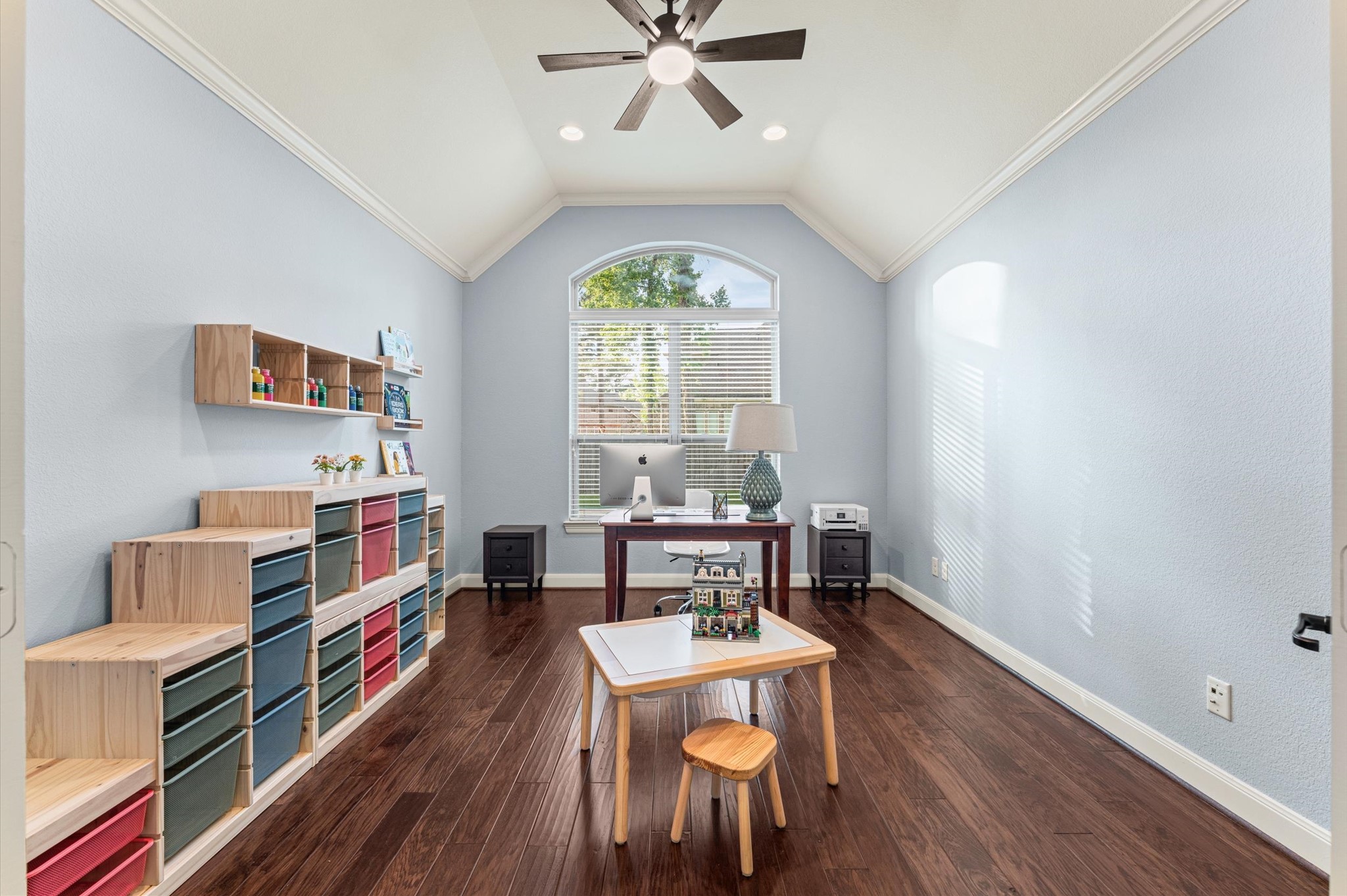 70 Valera Ridge Drive Spring, TX 77389 - Photo 25 of 37 Bright, spacious room with vaulted ceiling, large window, and hardwood floors. Features built-in shelving, a central desk, and a ceiling fan, perfect for a home office or playroom.