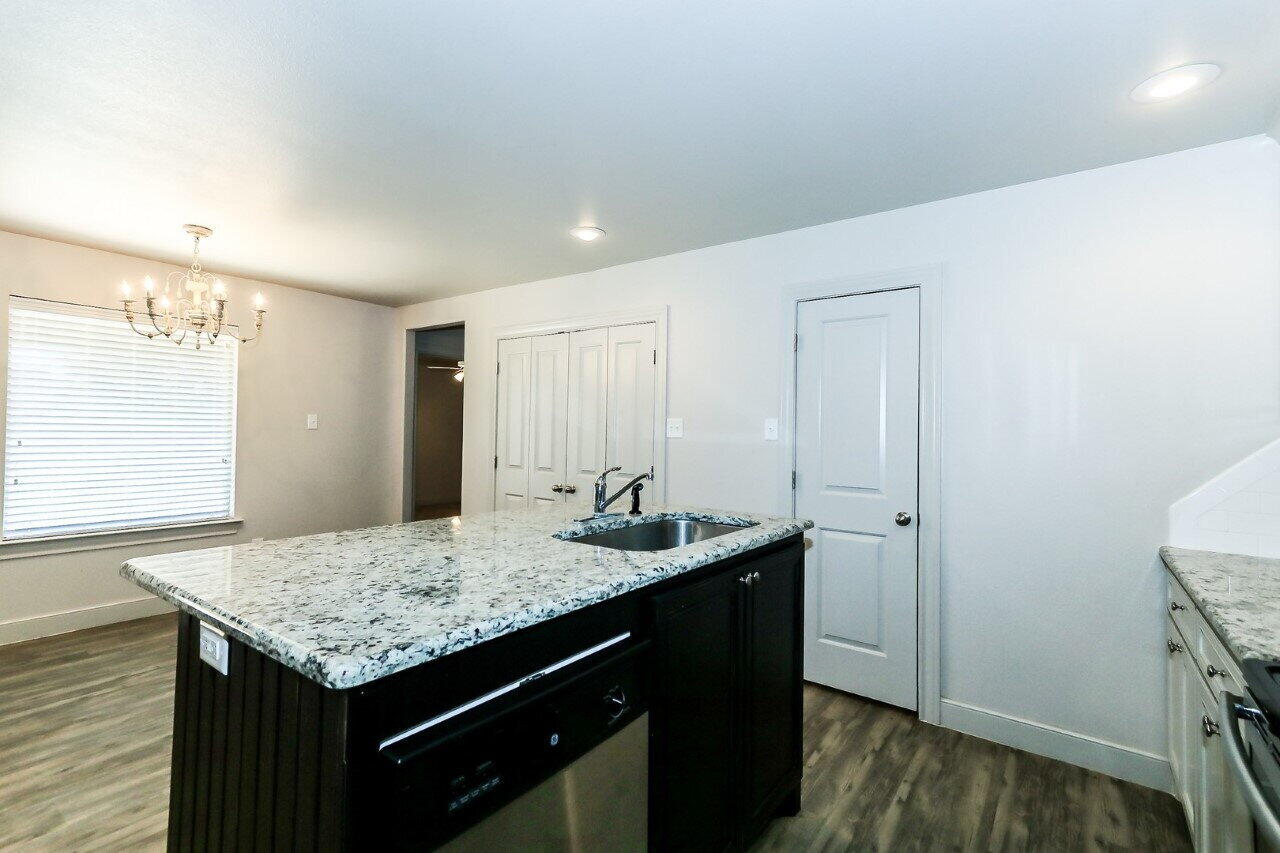 3814 133rd Street, Unit B Lubbock, TX 79423 - Photo 6 of 13 a bathroom with a granite countertop sink and a mirror
