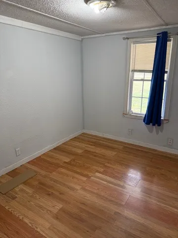 an empty room with wooden floor and a window