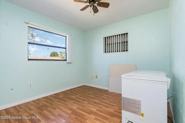 a view of a room with a ceiling fan and a window
