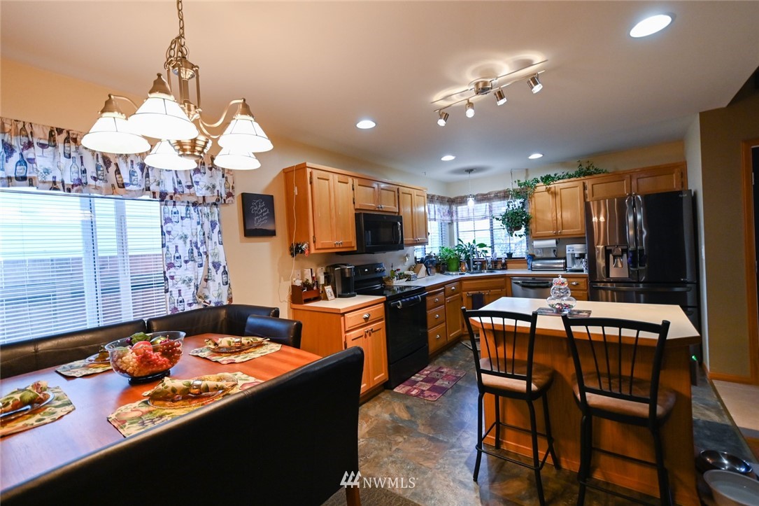 1018 Gohr Road Sultan, WA 98294 - Photo 6 of 16 a kitchen with stainless steel appliances granite countertop a stove top oven a sink dishwasher and a dining table with wooden floor