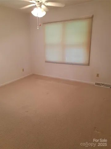 an empty room with a chandelier fan