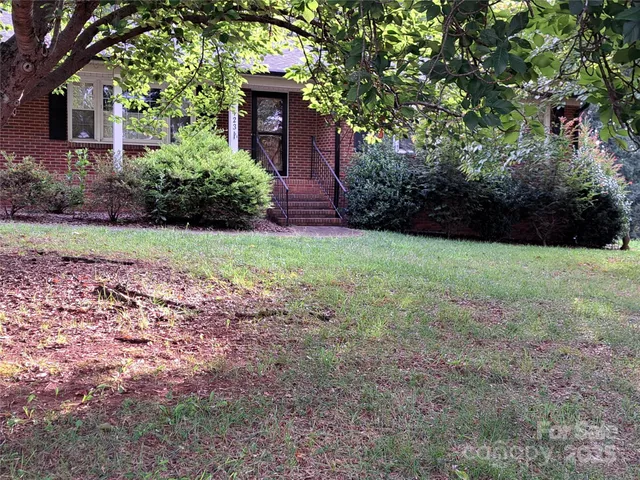 a view of a backyard with potted plants and large trees