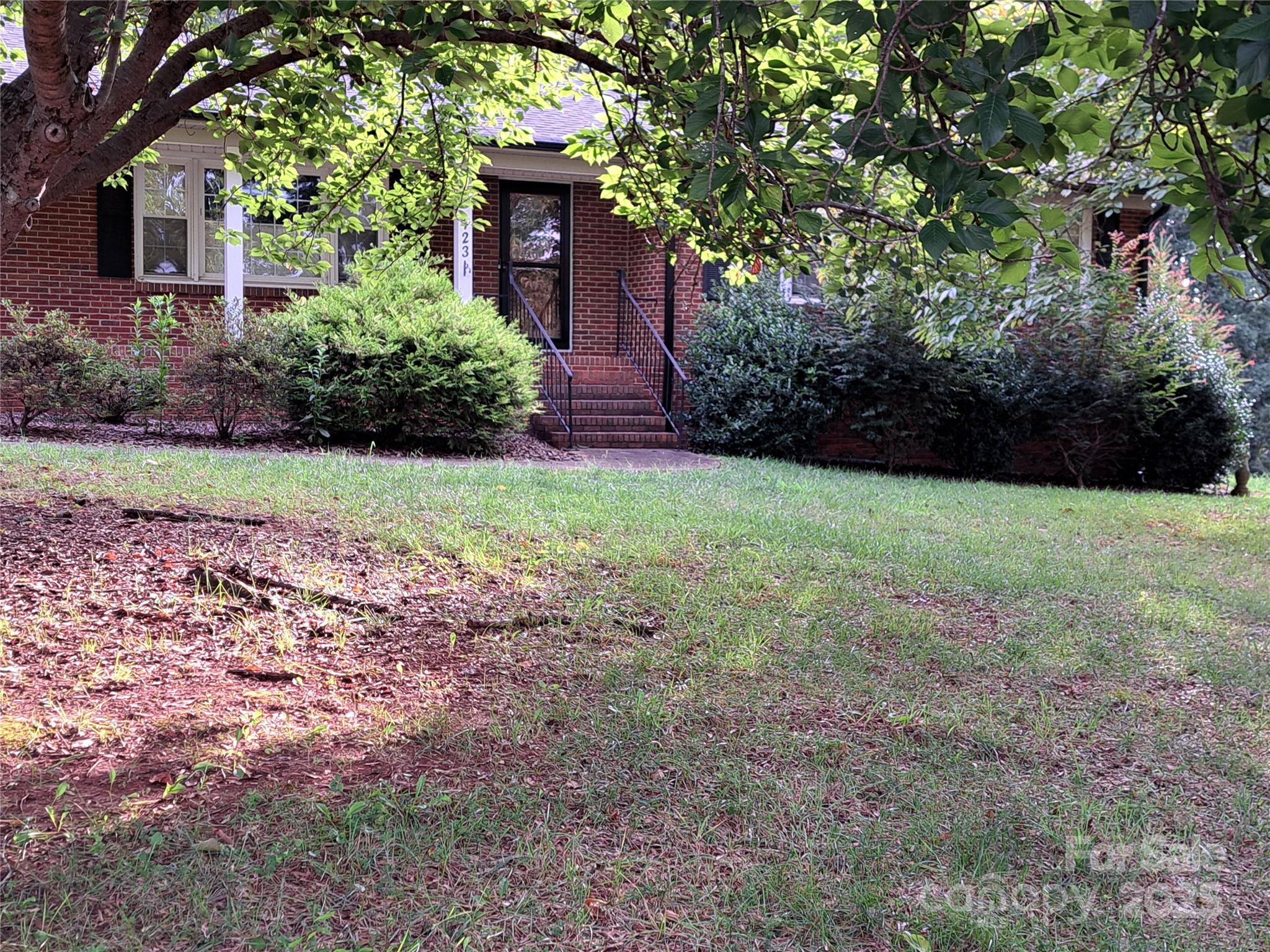 123 Softwind Lane Concord, NC 28025 - Photo 3 of 42 a view of a backyard with potted plants and large trees