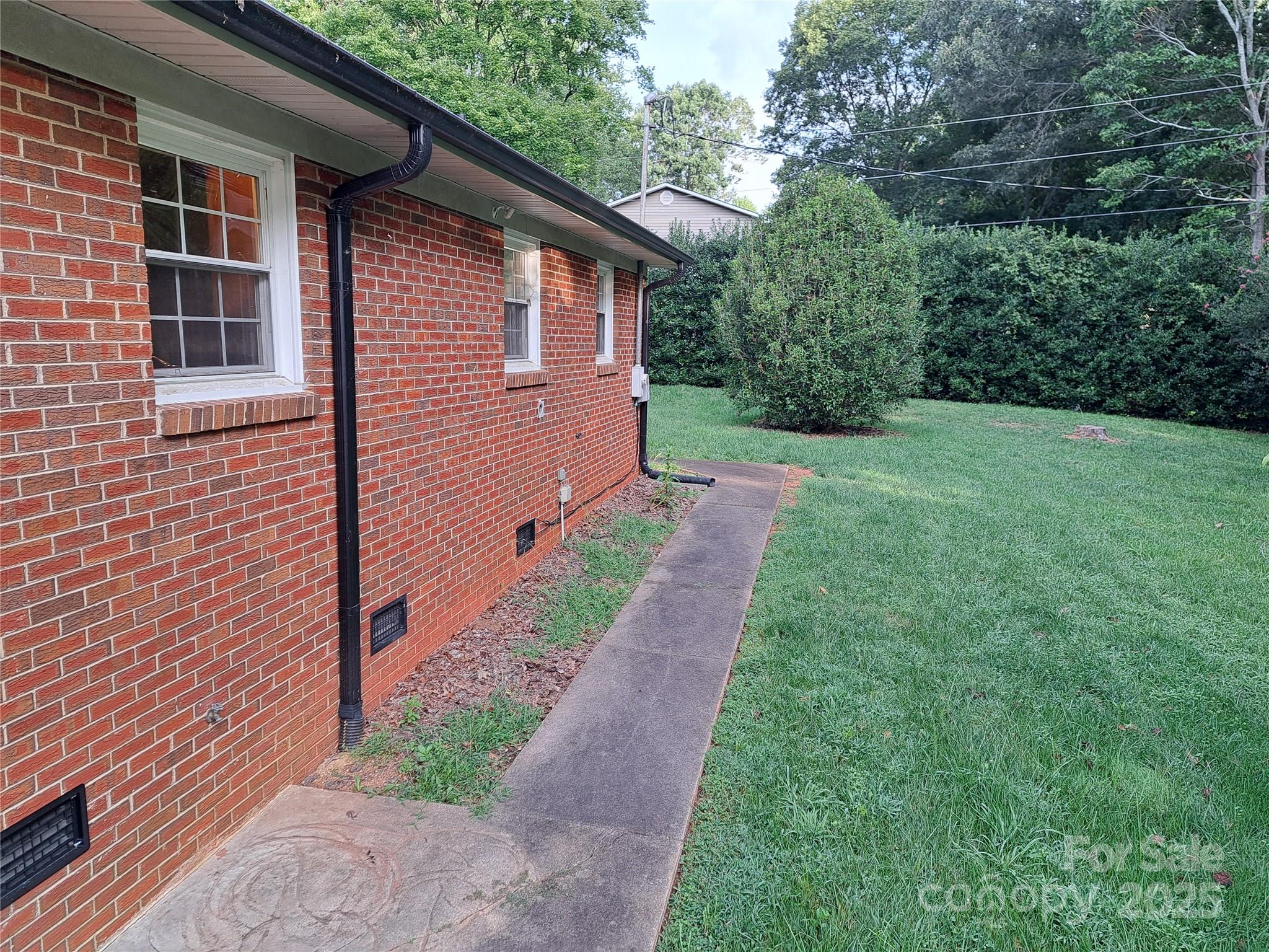 123 Softwind Lane Concord, NC 28025 - Photo 32 of 42 a view of a backyard with potted plants and large tree
