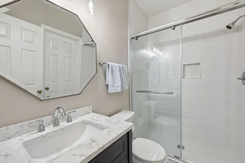 a bathroom with a granite countertop sink toilet and shower