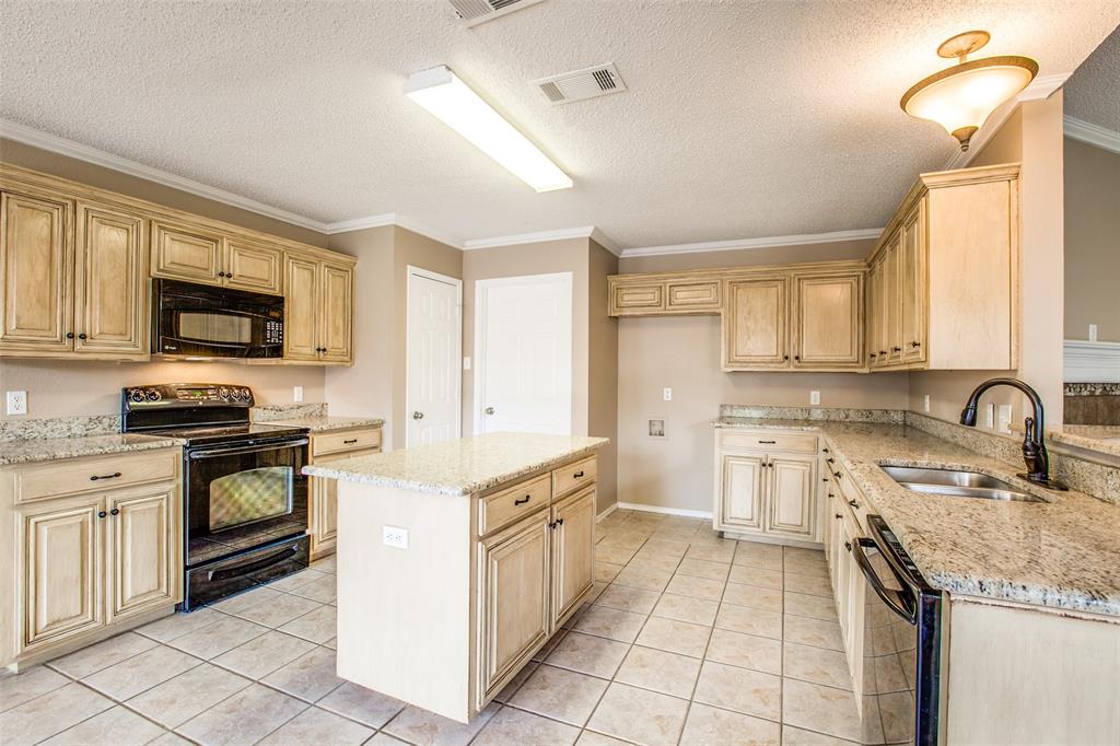14 Enchanted Court Mansfield, TX 76063 - Photo 11 of 25 a kitchen with a sink stove top oven and refrigerator