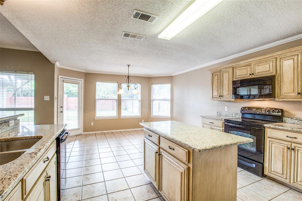 14 Enchanted Court Mansfield, TX 76063 - Photo 12 of 25 a kitchen with granite countertop a sink stove and cabinets
