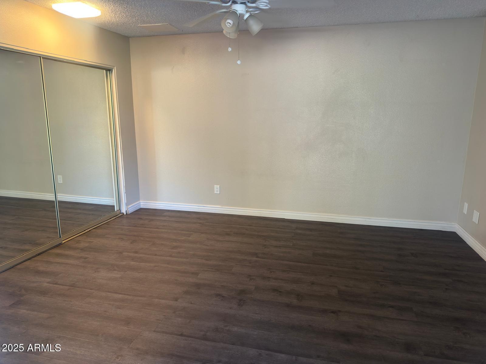 7728 North 47th Drive Glendale, AZ 85301 - Photo 11 of 23 an empty room with wooden floor and fan