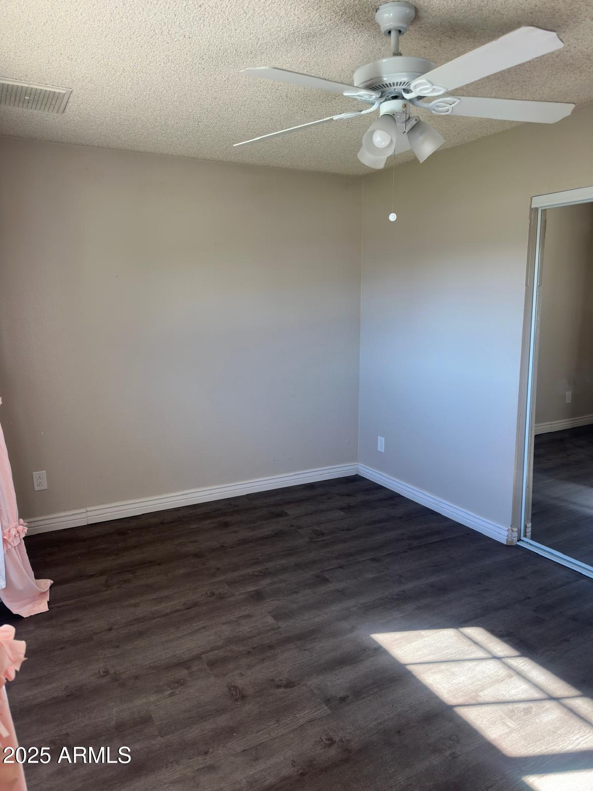 7728 North 47th Drive Glendale, AZ 85301 - Photo 7 of 23 an empty room with wooden floor and fan
