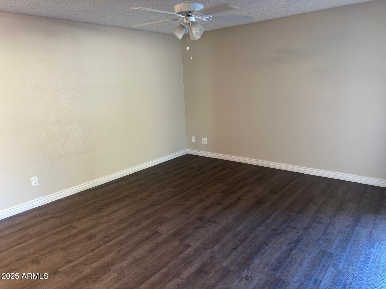 7728 North 47th Drive Glendale, AZ 85301 - Photo 9 of 23 a view of a room with wooden floor and a ceiling fan
