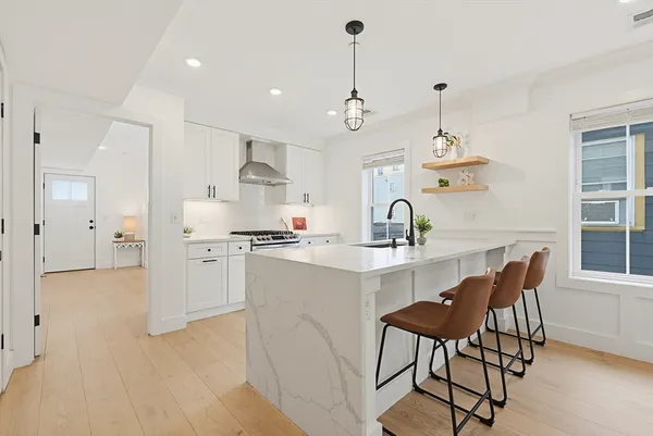 a kitchen with stainless steel appliances kitchen island granite countertop a sink refrigerator and cabinets