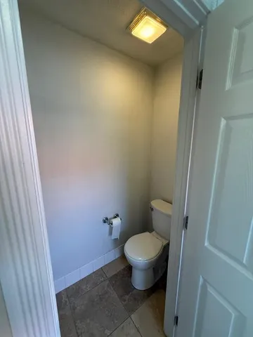 a bathroom with a granite countertop toilet and a sink