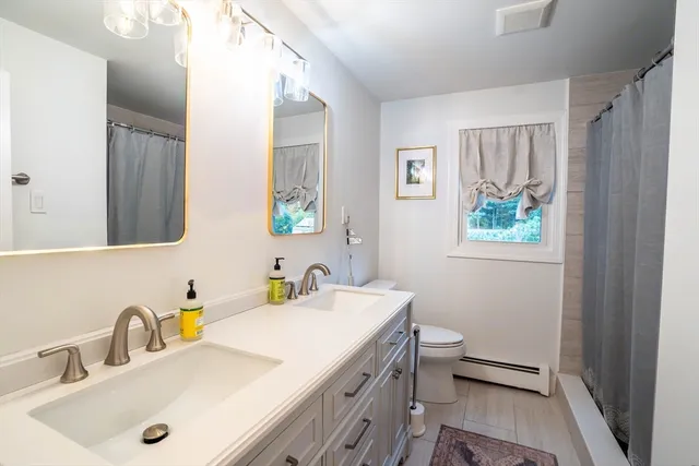 a bathroom with a sink a toilet and a mirror