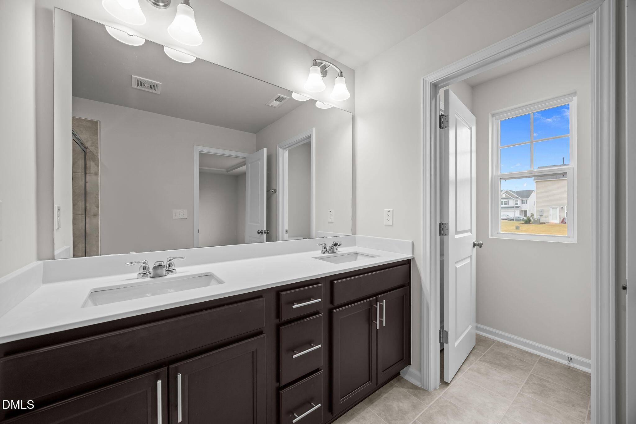 5016 Kota Street Raleigh, NC 27610 - Photo 12 of 37 a bathroom with a double vanity sink and a mirror