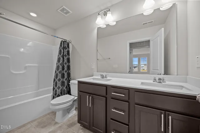 a bathroom with a double vanity sink toilet and shower