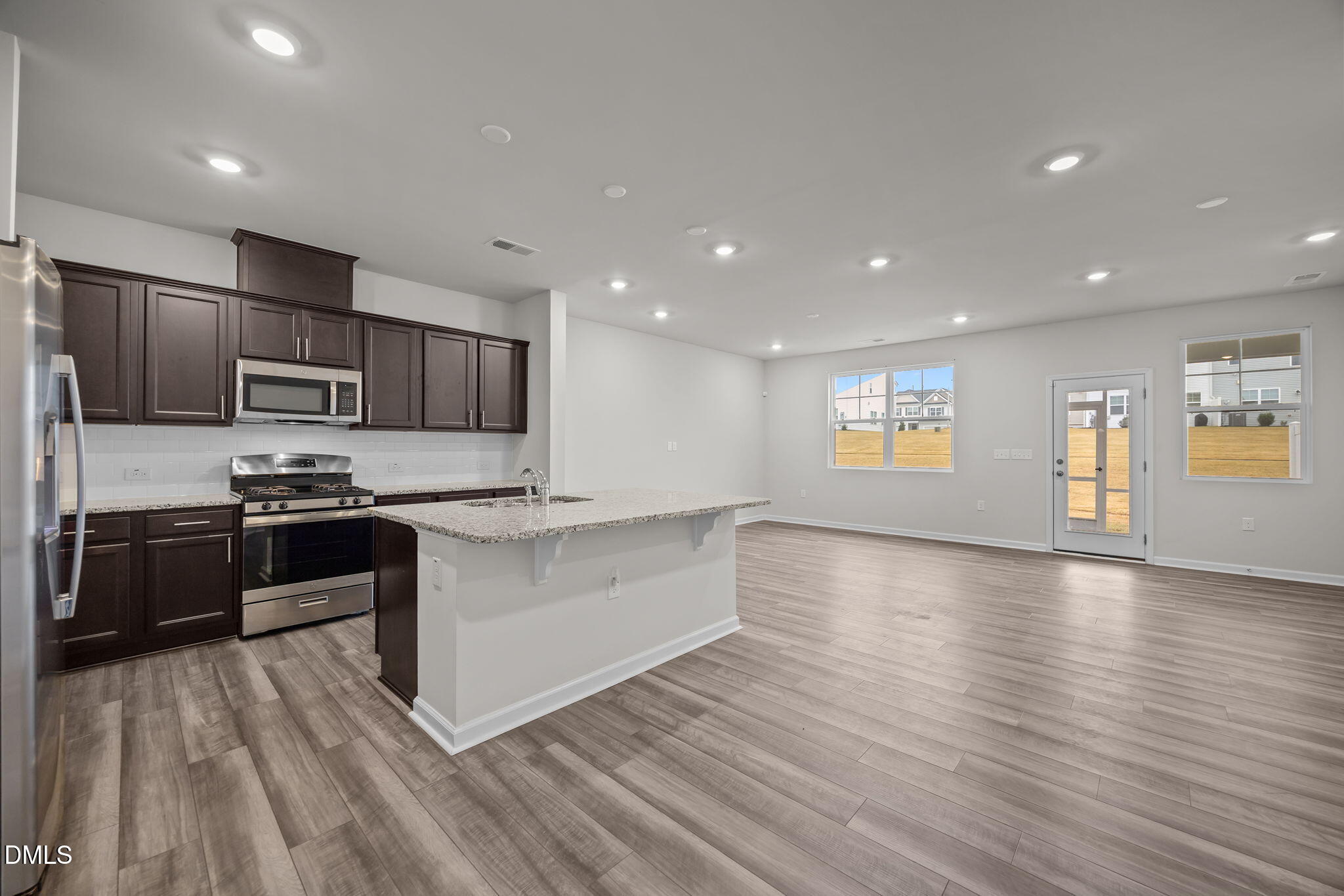 5016 Kota Street Raleigh, NC 27610 - Photo 21 of 37 a large kitchen with stainless steel appliances granite countertop a lot of cabinets and wooden floor