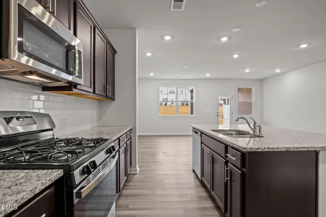 a kitchen with stainless steel appliances granite countertop a stove and a sink