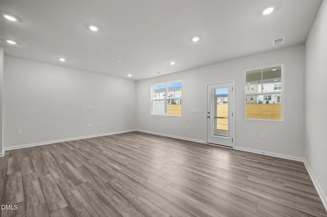 an empty room with window and wooden floor