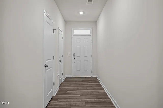 a view of a hallway with wooden floor and closet