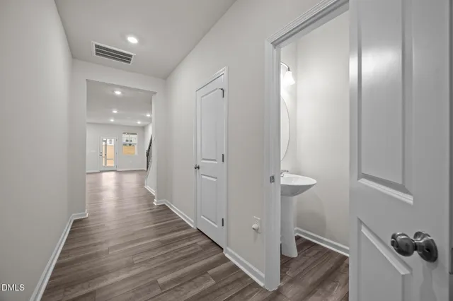 a view of a hallway with wooden floor and staircase