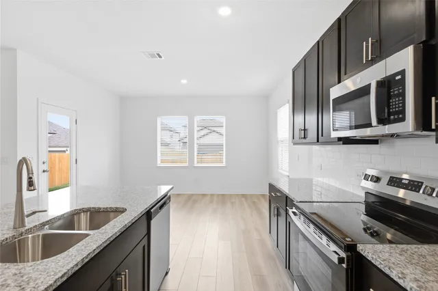 a kitchen with stainless steel appliances granite countertop a sink stove and microwave