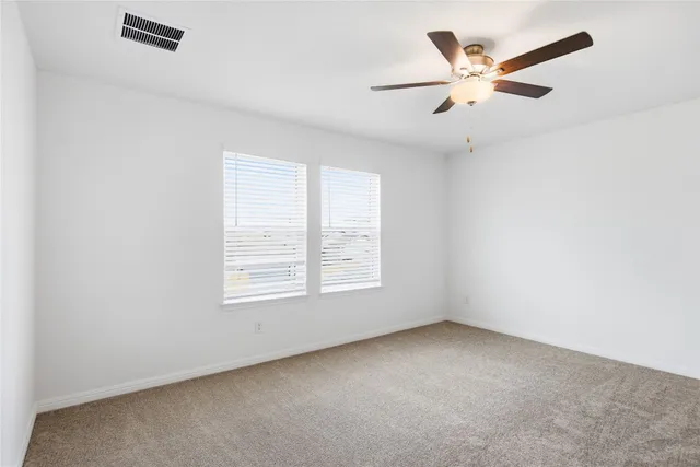 an empty room with a window and a fan