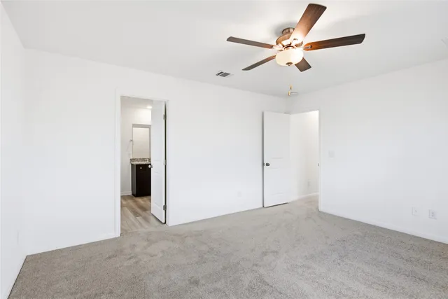 an empty room with closet and fan