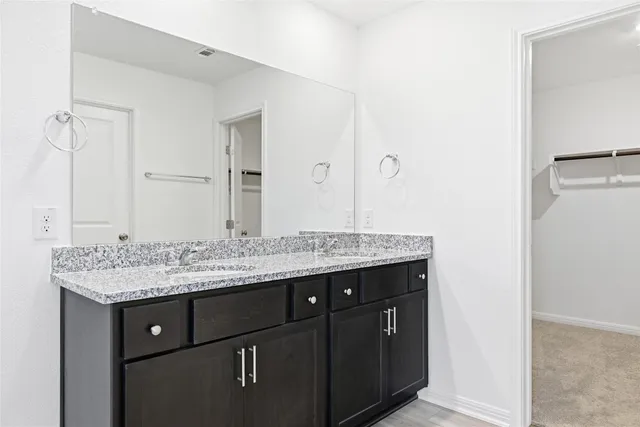 a bathroom with a granite countertop sink a toilet and a mirror