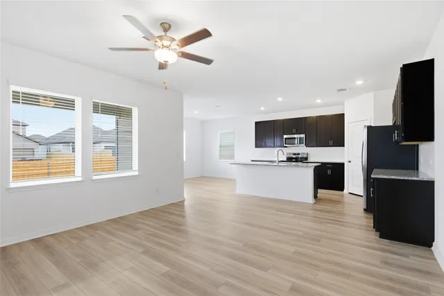 a view of kitchen with microwave a refrigerator and microwave