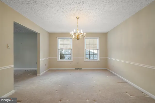 a view of an empty room with wooden floor and a fireplace