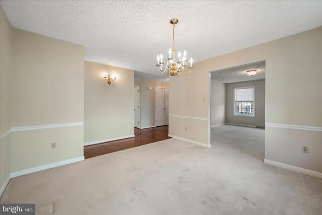 a view of an empty room with wooden floor and a fireplace