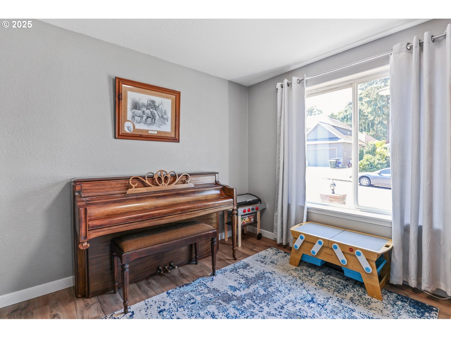 701 South 68th Place Springfield, OR 97478 - Photo 21 of 28 a living room with a piano a rug and a window
